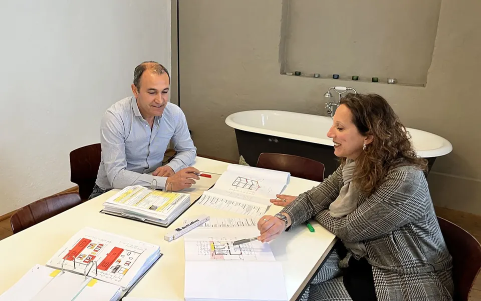 Planungsgespräch am Tisch mit Bauplänen